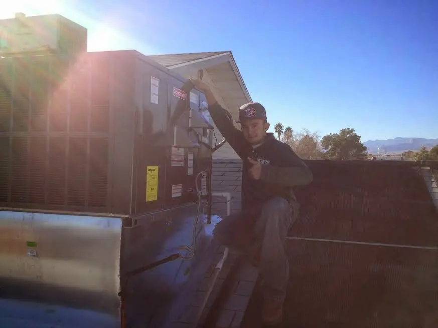 HVAC technician performing AC Tune-Up on a rooftop unit in Inver Grove Heights